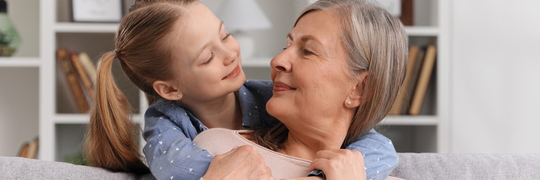 A little granddaughter hugs her 60-year-old grandmother, shows love.